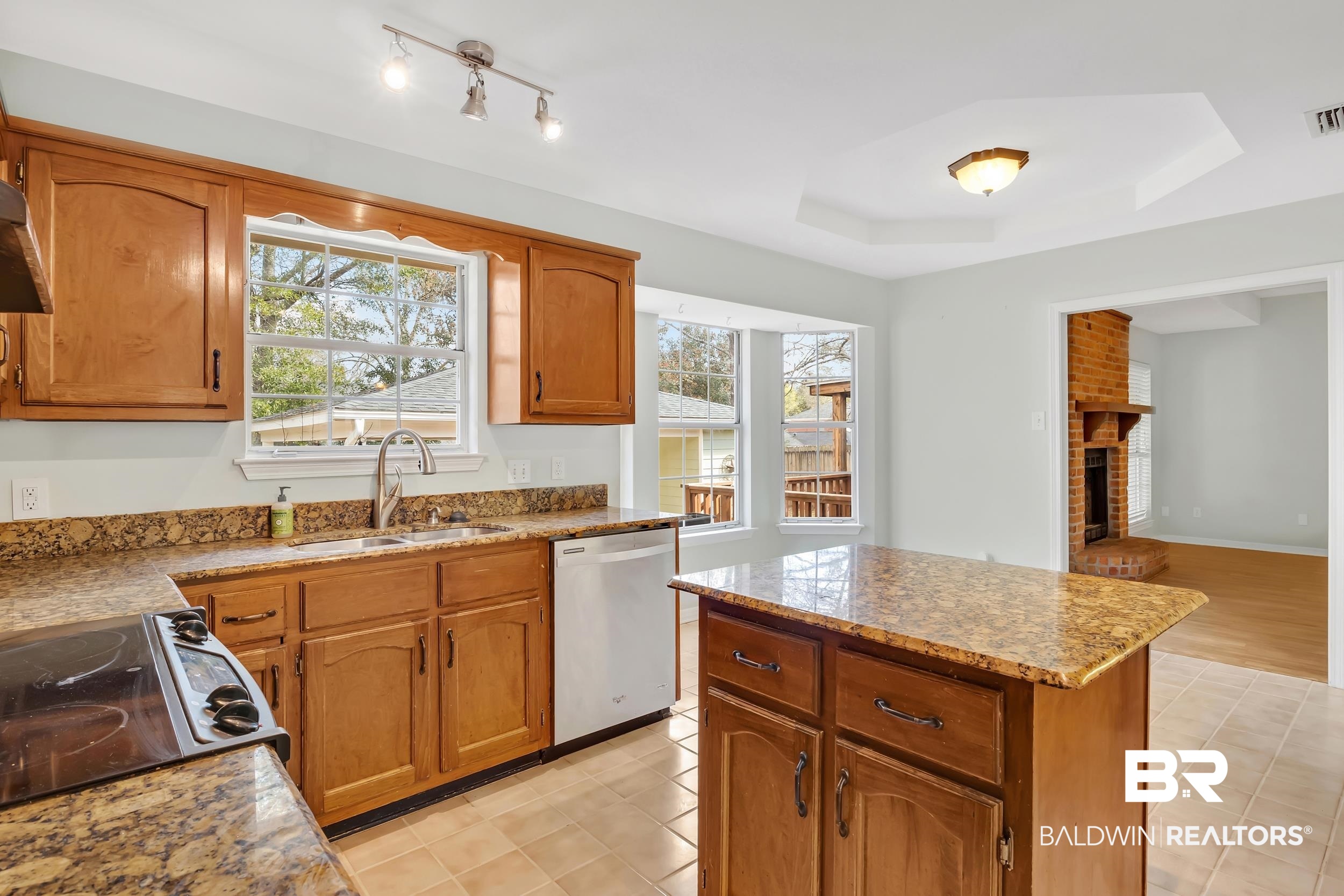 6616 Conde Court Mobile, AL 36695 - Photo 11 of 27 Kitchen featuring stainless steel dishwasher, brown cabinetry, electric range, a raised ceiling, and a sink