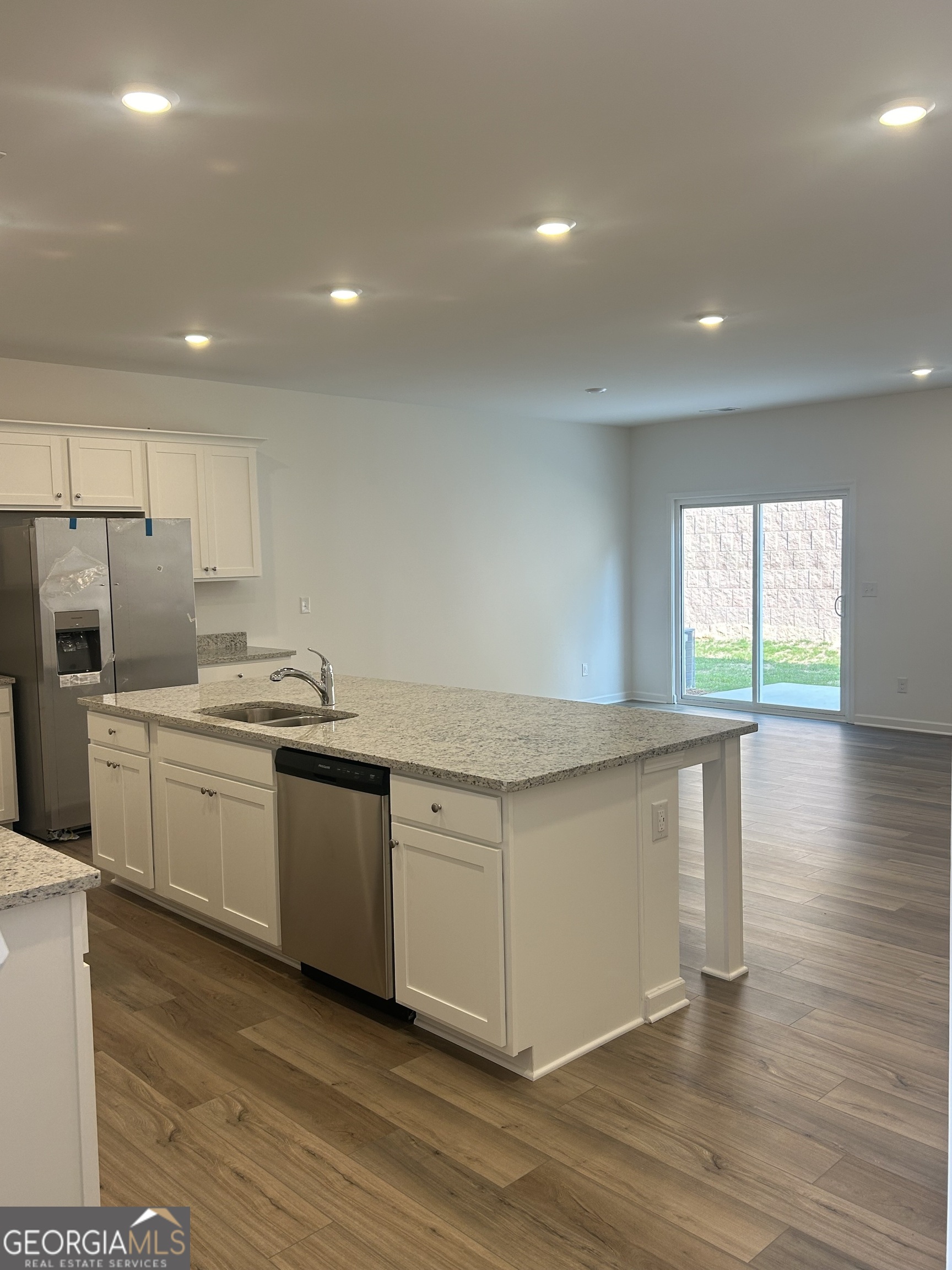160 Vision Street Bethlehem, GA 30620 - Photo 3 of 11 a kitchen with granite countertop a stove a sink and white cabinets with wooden floor