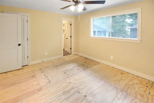 a view of an empty room with a chandelier fan