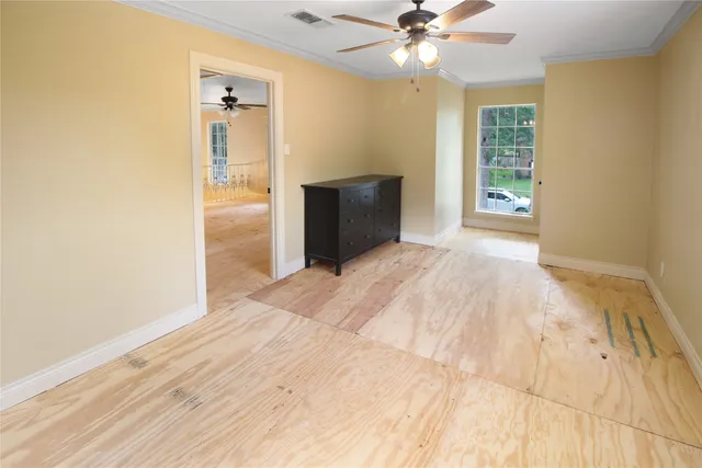 a view of an empty room with window and wooden floor