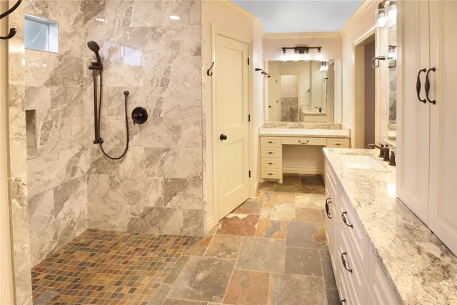 a bathroom with a granite countertop shower a mirror and a sink