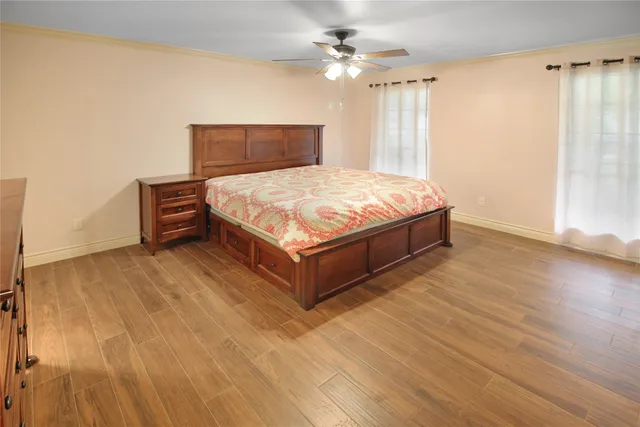 a spacious bedroom with a bed and wooden floor