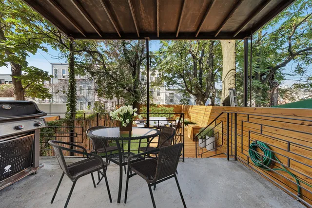 a large white kitchen with stainless steel appliances granite countertop a large counter top and a stove with wooden floor
