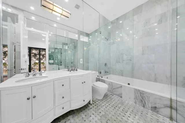 a bathroom with a double vanity sink toilet a mirror and shower