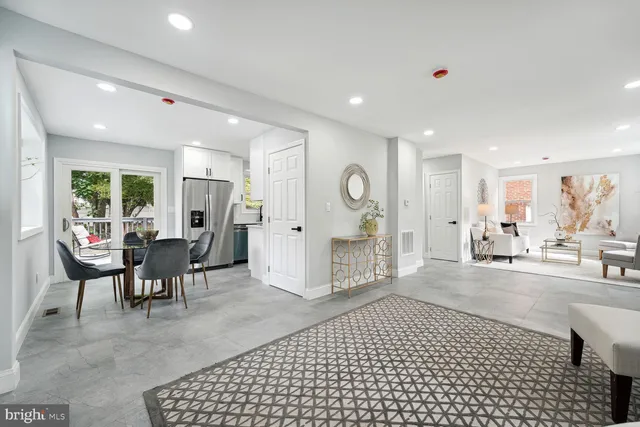 a living room with furniture a large window and glass table