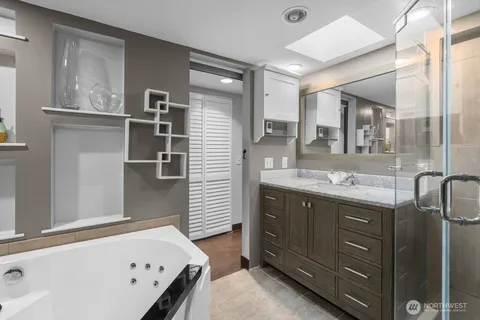 a bathroom with a tub sink and mirror