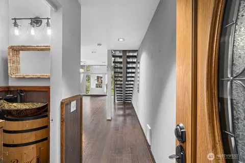 a walk in closet with wooden floor