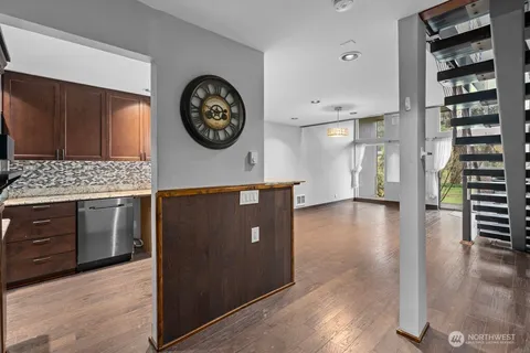 a view of a kitchen with fridge and wooden floor