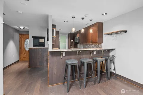 a kitchen with stainless steel appliances kitchen island granite countertop a table and chairs in it