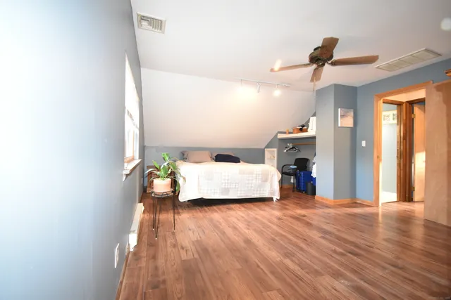 a bedroom with a bed and wooden floor