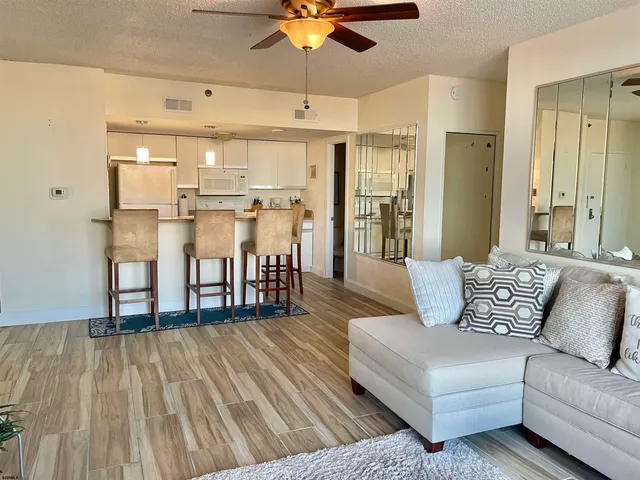 a living room with furniture and kitchen view