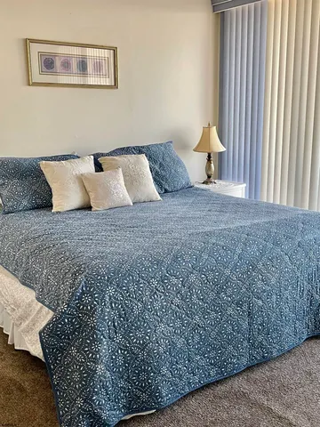 a bed sitting in a bedroom next to a window with a couch