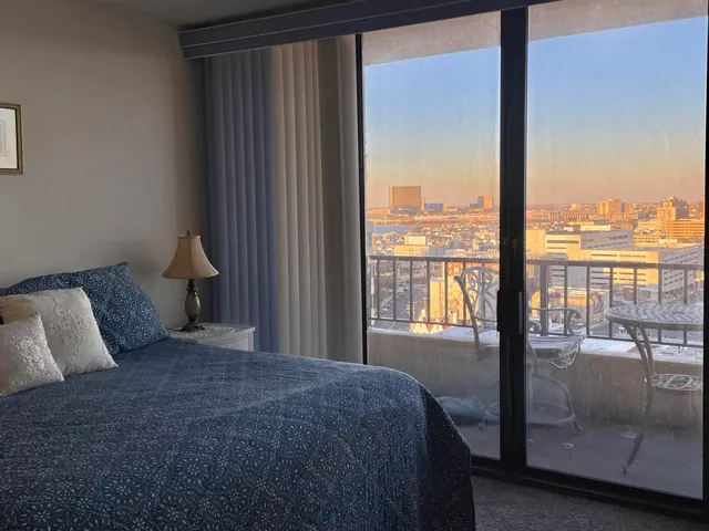 a bedroom with a large window and a balcony