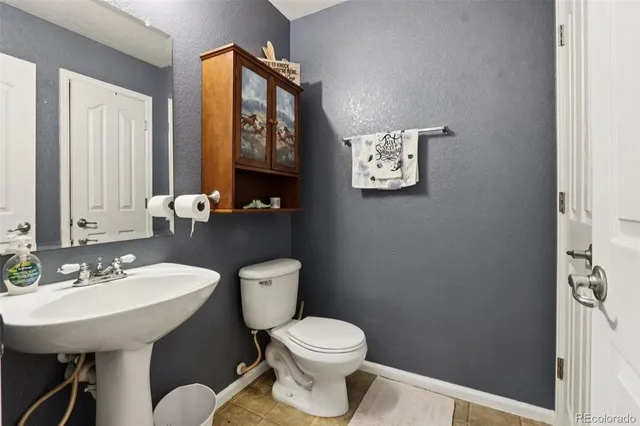 a bathroom with a toilet a sink and a mirror