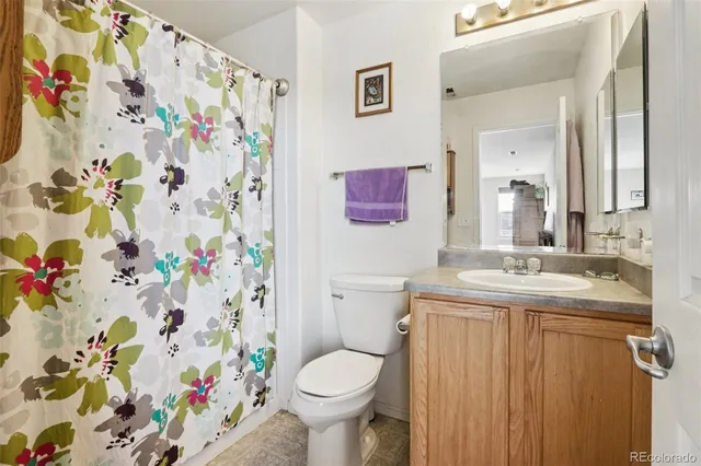 a bathroom with a granite countertop toilet sink and mirror
