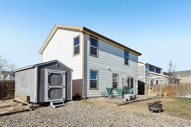 a backyard of a house with table and chairs