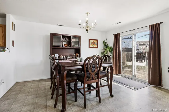 a view of a dining room with furniture and a chandelier