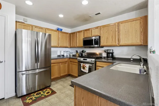 a kitchen with stainless steel appliances granite countertop a refrigerator stove top oven a sink and dishwasher