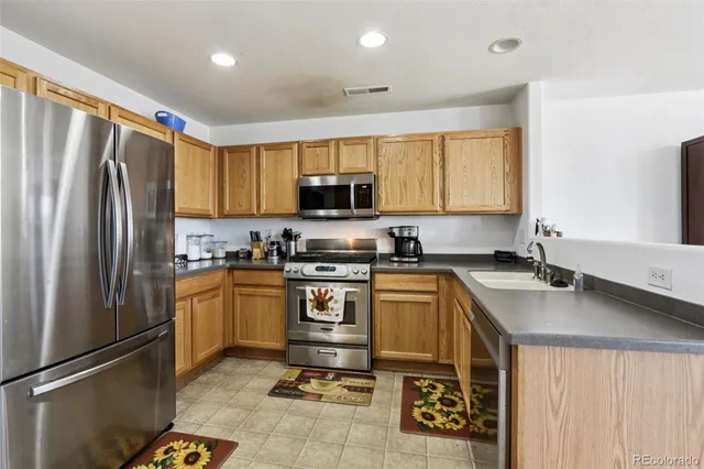 a kitchen with stainless steel appliances granite countertop a refrigerator sink and stove