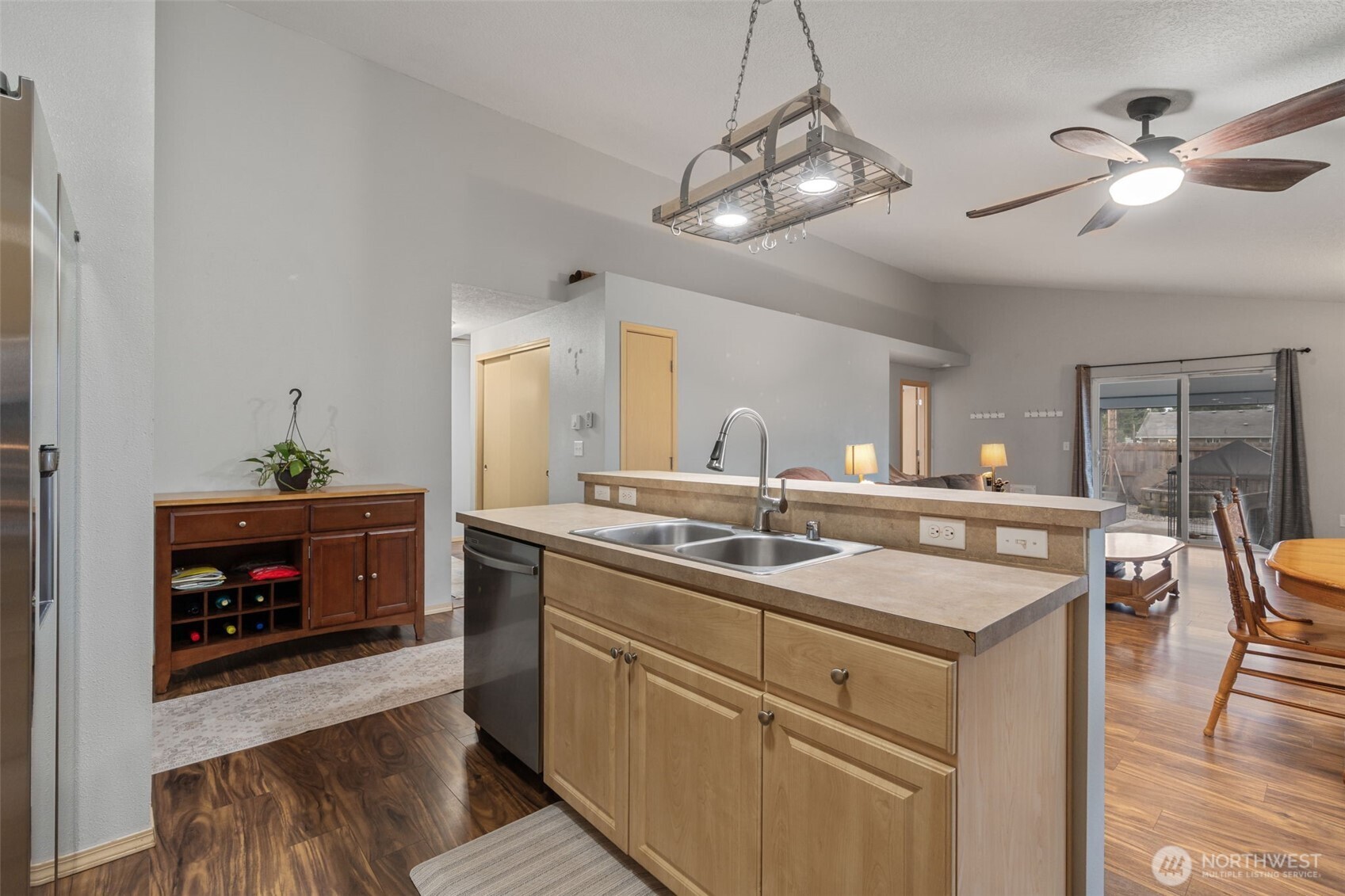 6321 199th Loop Southwest Rochester, WA 98579 - Photo 11 of 38 a kitchen with a sink dishwasher and white cabinets with wooden floor