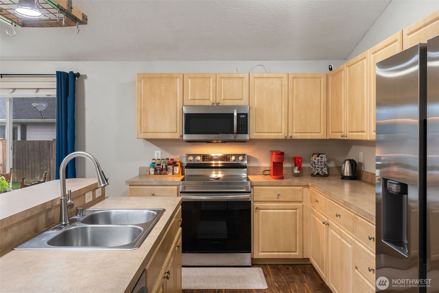 6321 199th Loop Southwest Rochester, WA 98579 - Photo 10 of 38 a kitchen with granite countertop a sink stainless steel appliances and cabinets