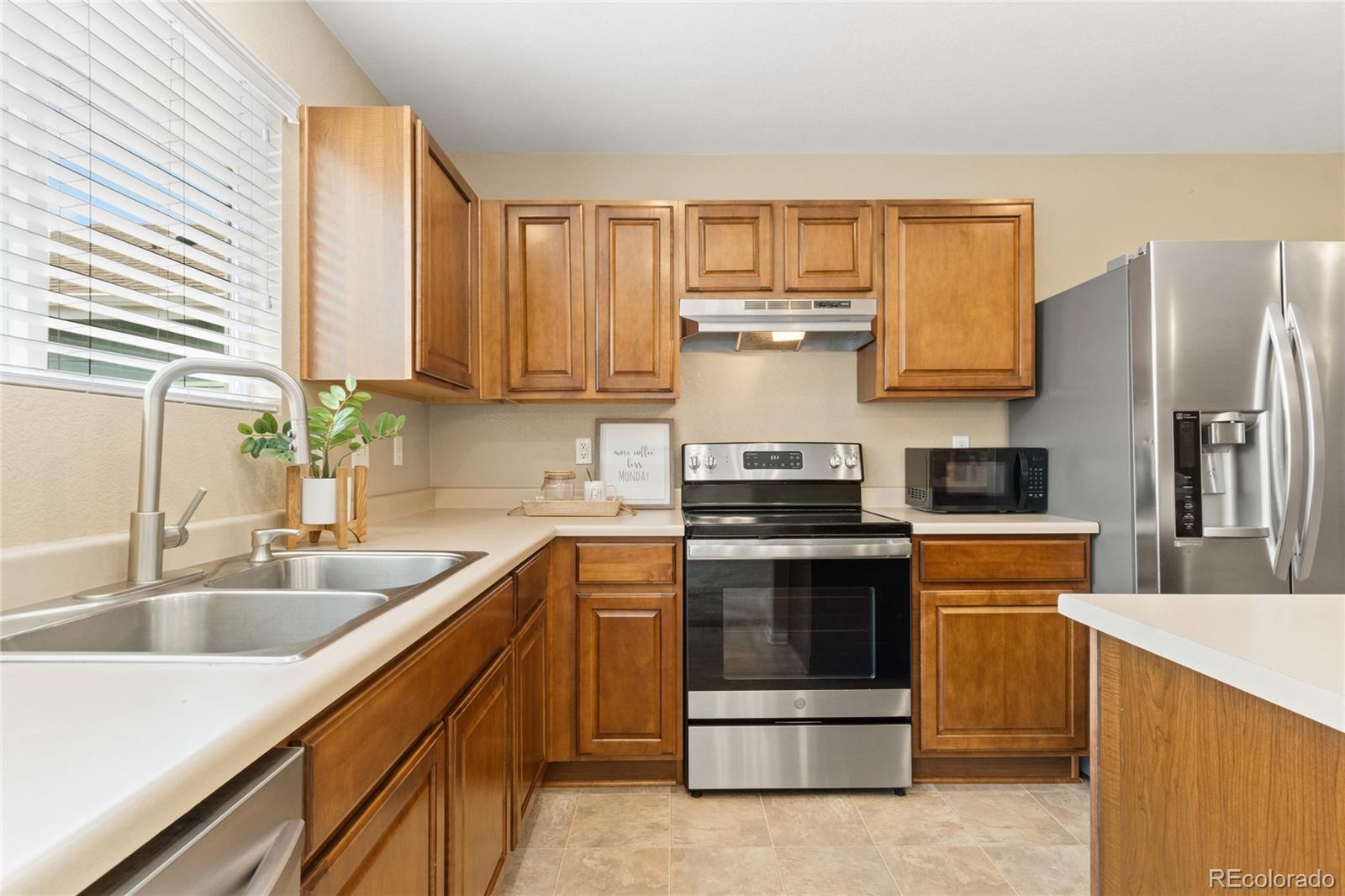 5831 Ceylon Street Denver, CO 80249 - Photo 5 of 14 a kitchen with a sink stove and refrigerator
