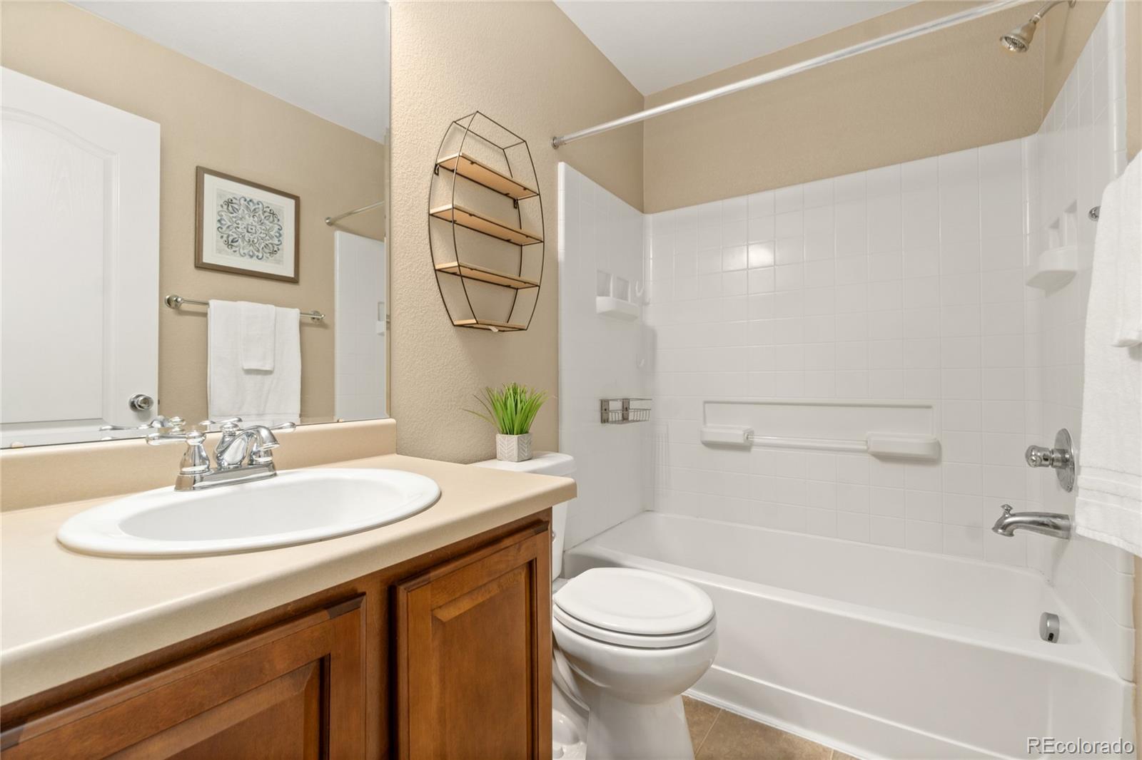 5831 Ceylon Street Denver, CO 80249 - Photo 8 of 14 a bathroom with a sink a toilet and shower