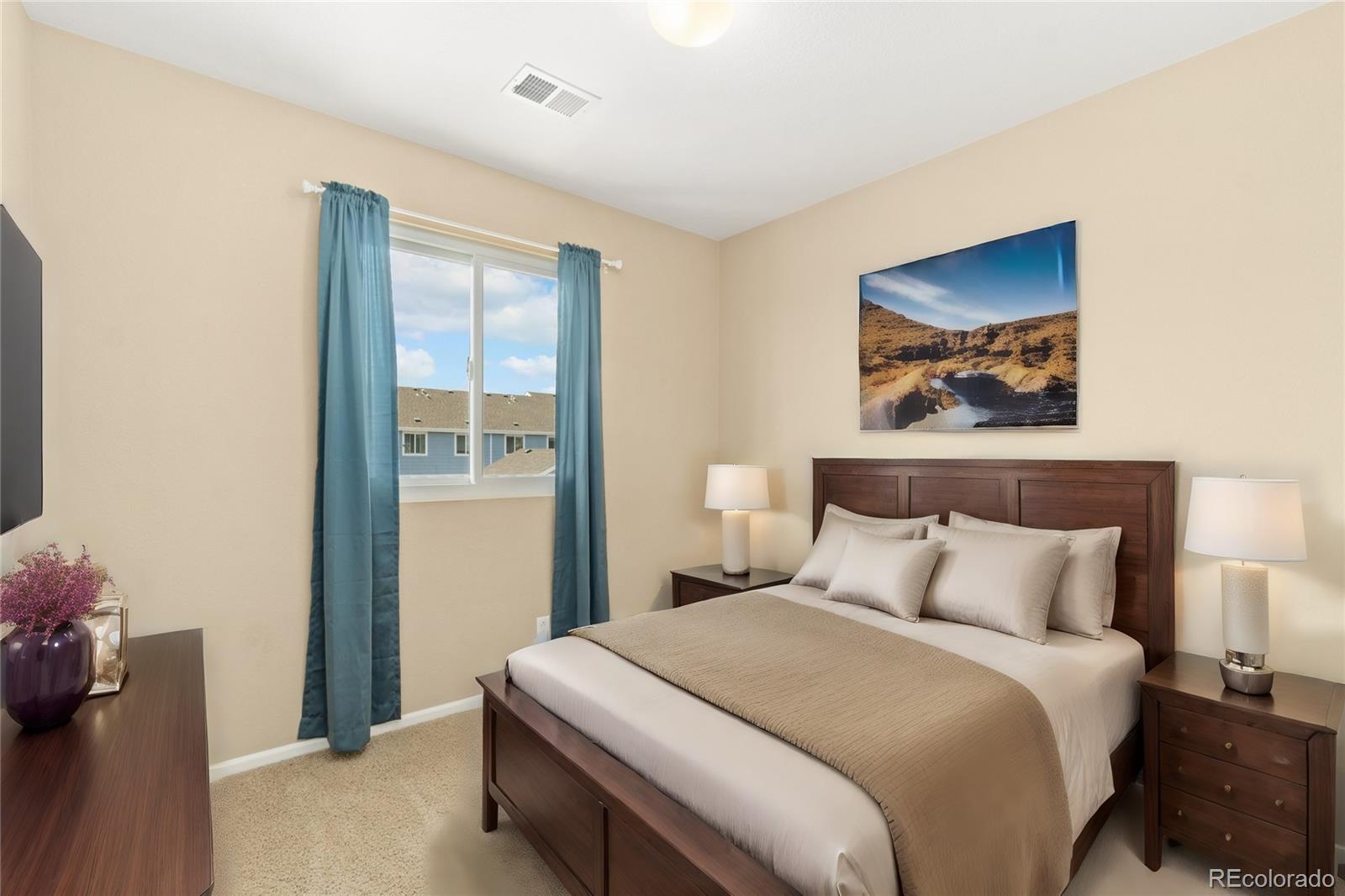 5831 Ceylon Street Denver, CO 80249 - Photo 9 of 14 a bedroom with a bed and a painting on the wall