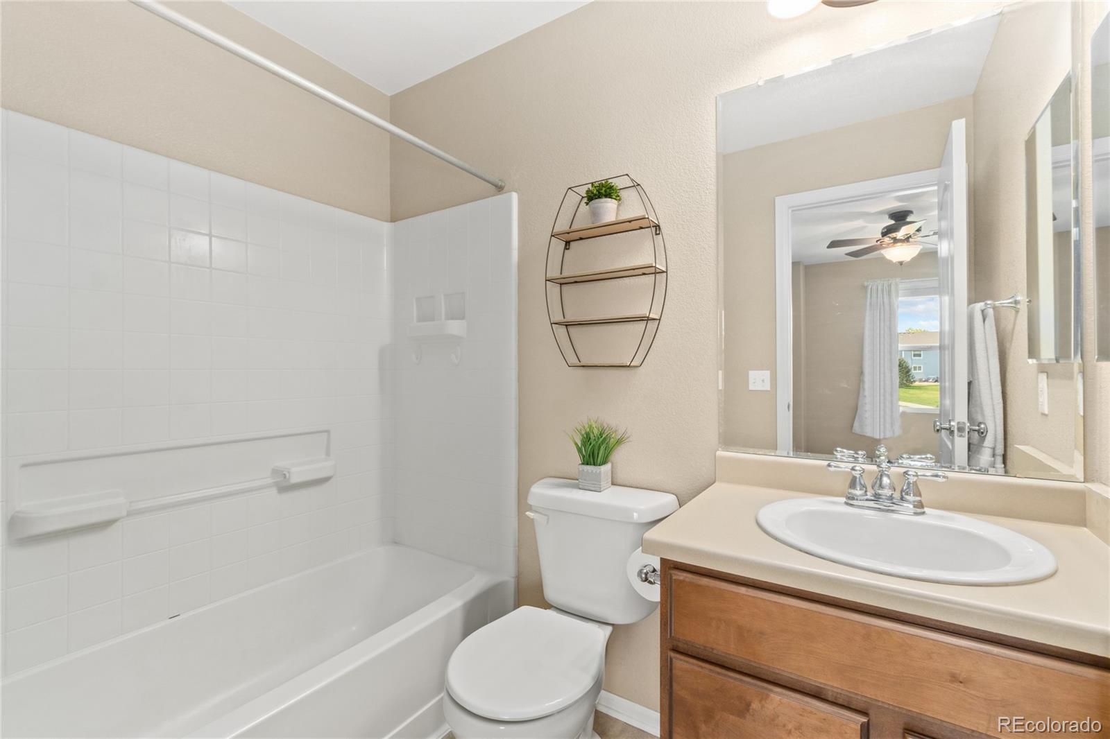 5831 Ceylon Street Denver, CO 80249 - Photo 10 of 14 a bathroom with a sink a toilet and shower