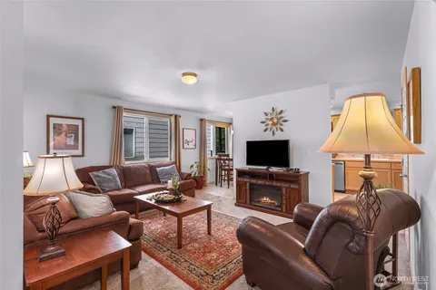 a living room with furniture a flat screen tv and a fireplace