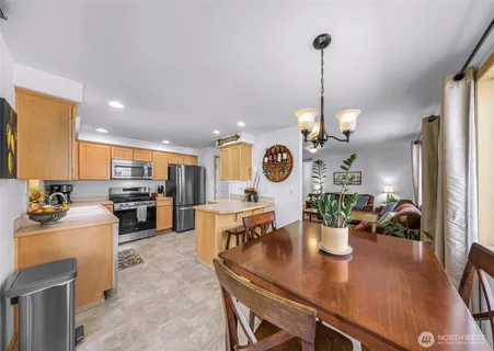 a view of a dining room and livingroom with furniture wooden floor a chandelier