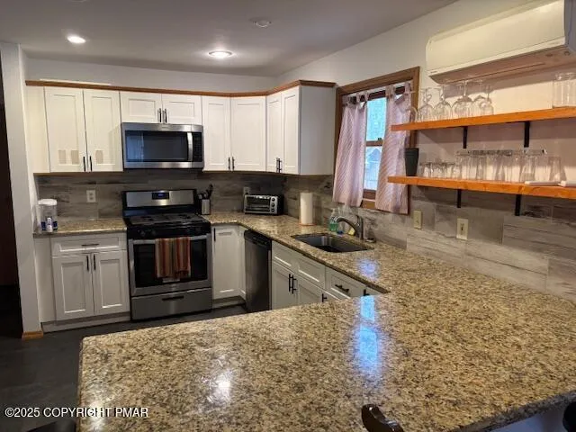 a kitchen with stainless steel appliances granite countertop a stove a sink and a microwave