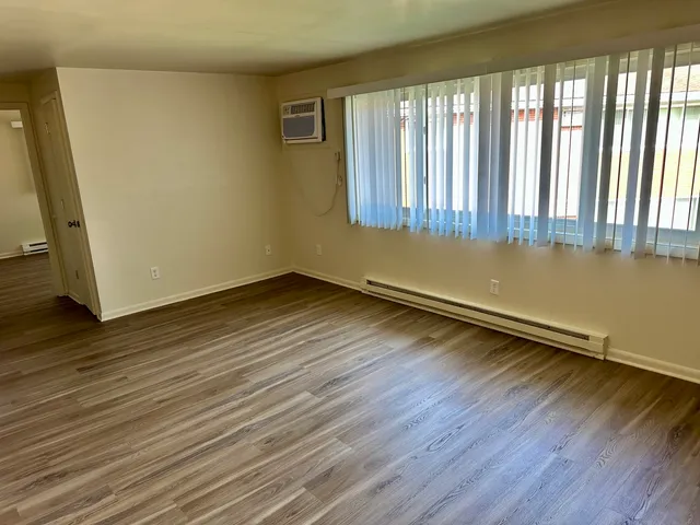 a view of a room with wooden floor and a window