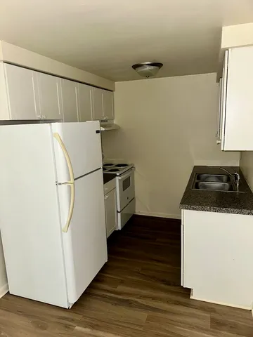 a utility room with wooden floor washer and dryer