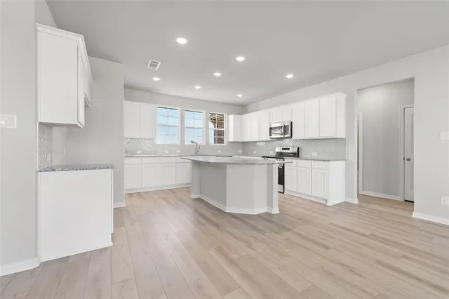 a kitchen with a white wooden cabinets and white stainless steel appliances