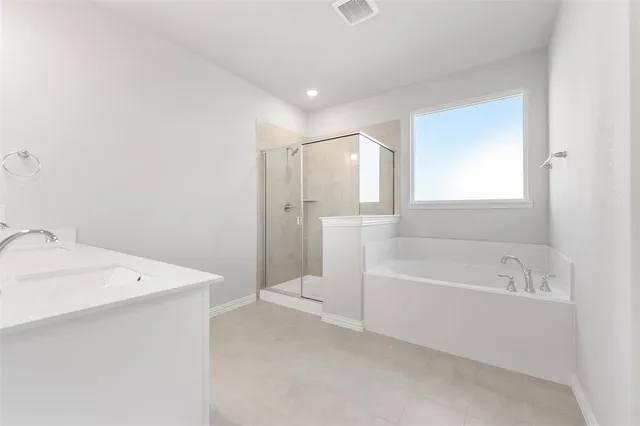 a bathroom with a tub a sink and a window