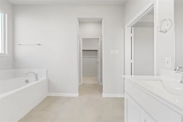 a bathroom with a tub shower sink and vanity