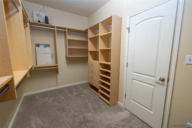 a view of walk in closet with empty racks