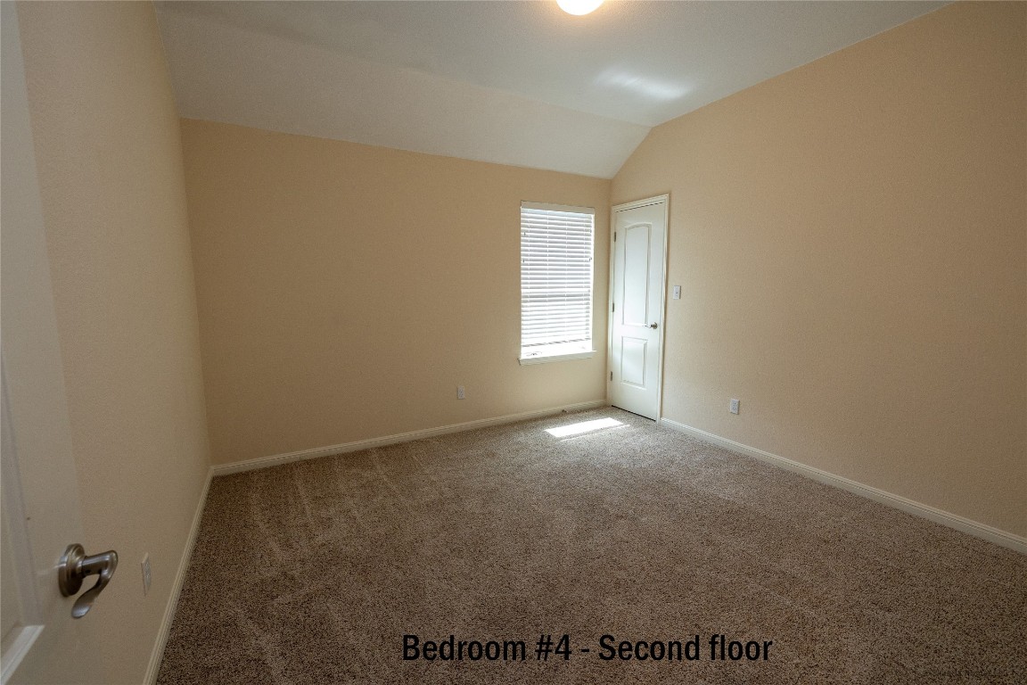 104 Palisades Cove Austin, TX 78732 - Photo 21 of 27 Carpeted empty room featuring lofted ceiling and baseboards