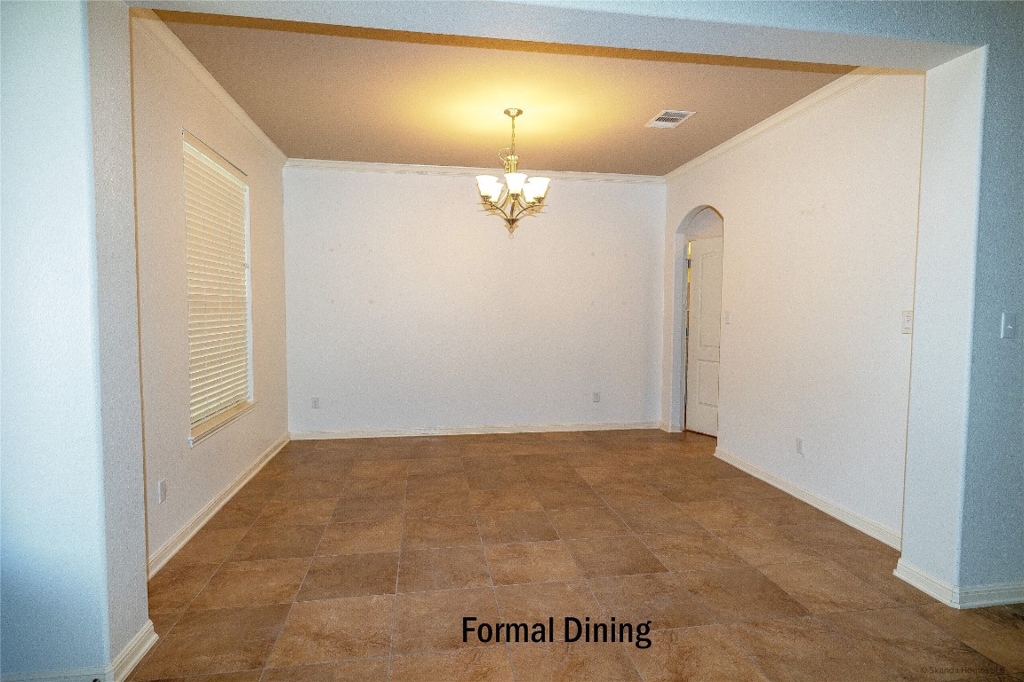 104 Palisades Cove Austin, TX 78732 - Photo 3 of 27 Unfurnished dining area featuring ornamental molding, arched walkways, and a chandelier