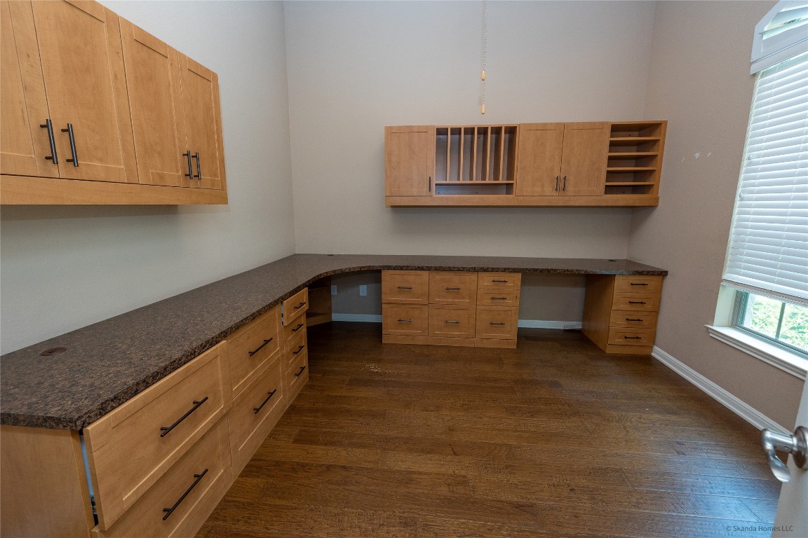 104 Palisades Cove Austin, TX 78732 - Photo 4 of 27 Unfurnished office featuring built in desk and dark wood finished floors