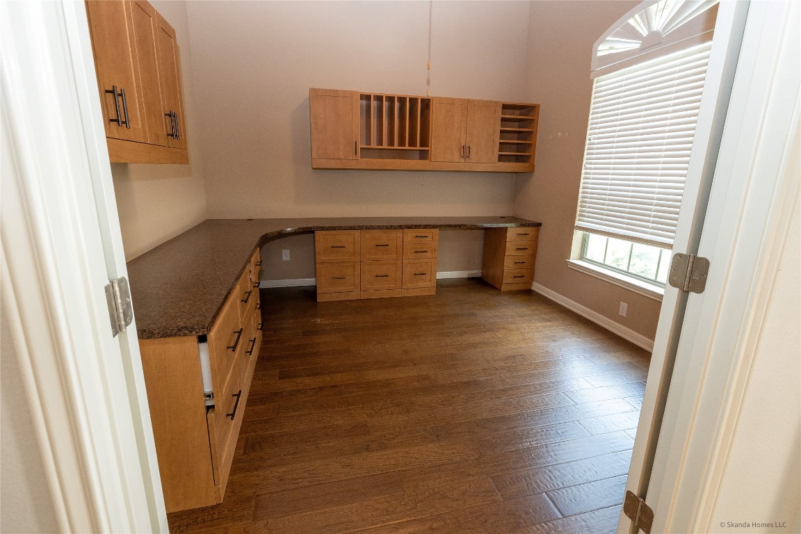 104 Palisades Cove Austin, TX 78732 - Photo 6 of 27 Unfurnished office with built in desk and dark wood finished floors