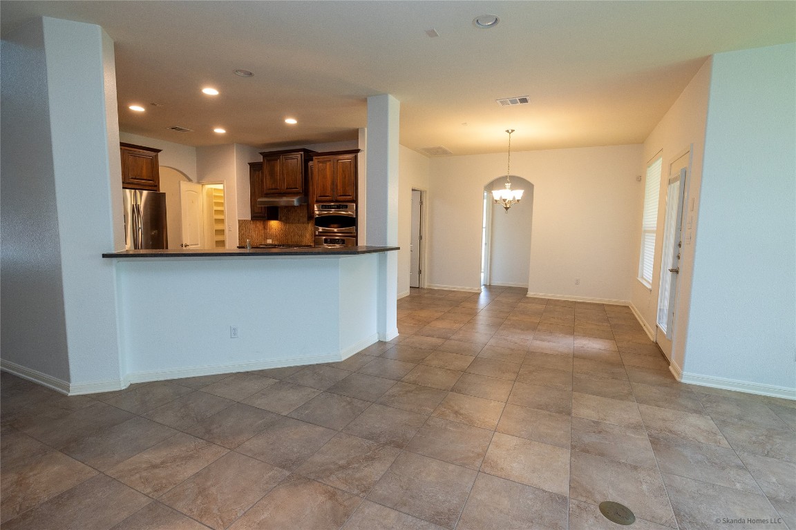 104 Palisades Cove Austin, TX 78732 - Photo 8 of 27 Kitchen with backsplash, recessed lighting, a chandelier, appliances with stainless steel finishes, and decorative light fixtures