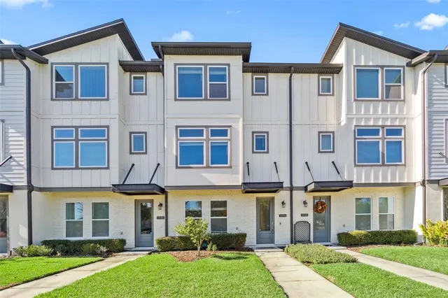 a view of a big house with a yard and plants