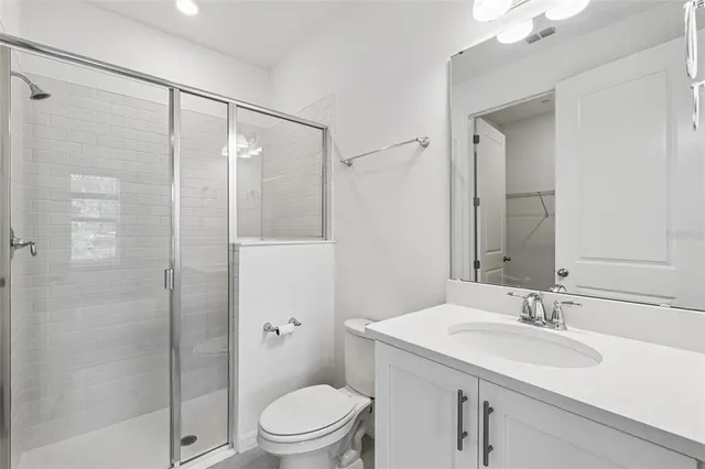 a bathroom with a sink toilet vanity and shower