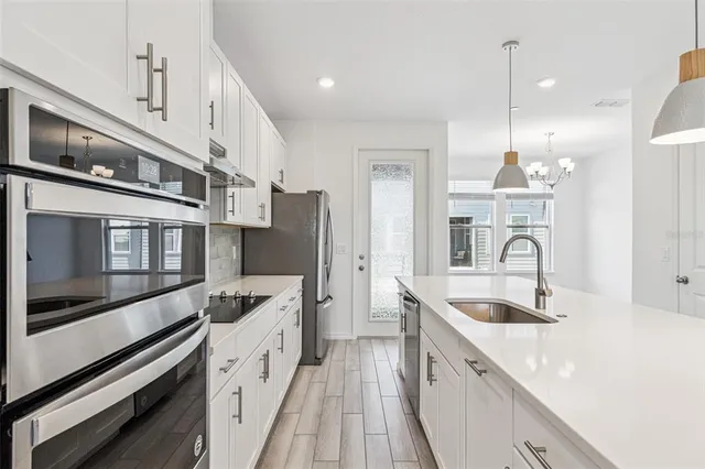 a kitchen with stainless steel appliances granite countertop a sink and a stove top oven with granite countertops