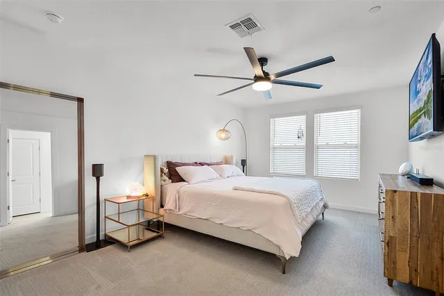 a bedroom with a bed chandelier and a window