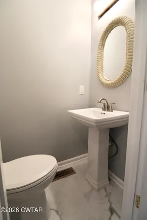 a bathroom with a toilet a sink and a mirror