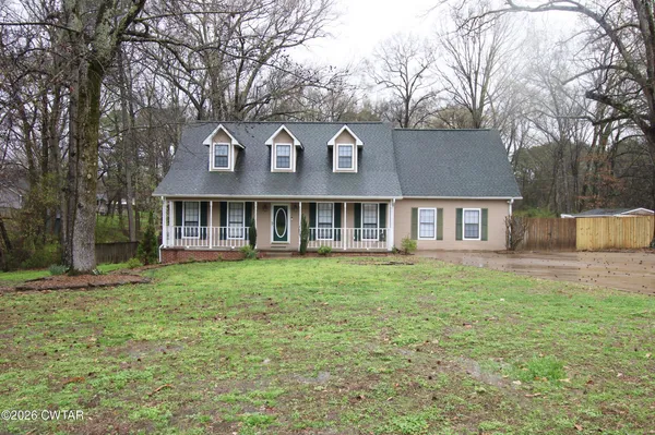 a view of a yard in front of a house with large tree