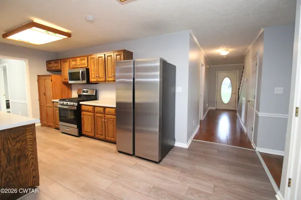 a kitchen with stainless steel appliances granite countertop a refrigerator a sink a stove and cabinets